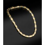 An 18ct two colour gold collar necklace, designed as a series of repeating tonneau-shaped panels