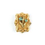 A Victorian turquoise set panel brooch, the foliate scroll cartouche applied with a spray of