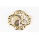 An early Victorian memorial brooch/pendant, centred with an oval glazed compartment containing