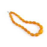 An amber bead necklace, comprising a single strand of amber beads, graduating from approximately