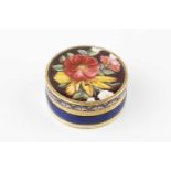 A 19th century French or Swiss gold and enamel circular vinaigrette, the cover decorated with a