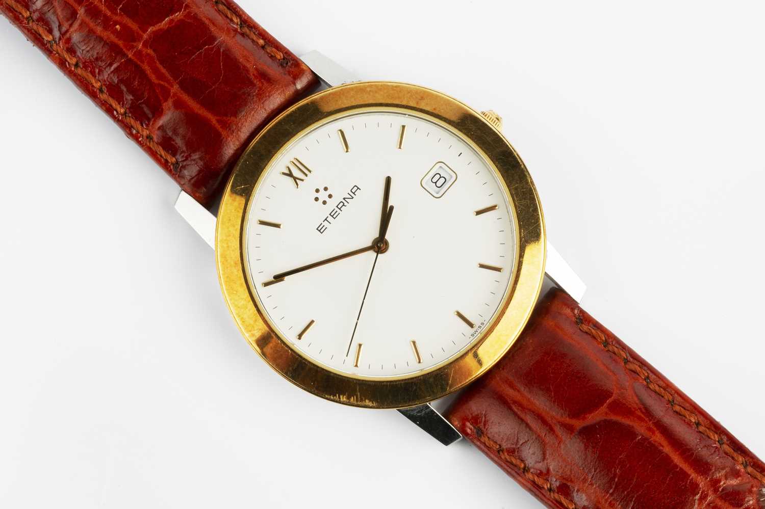 A bi-colour wristwatch by Eterna, the circular white dial with gilt baton markers, date display