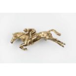A 9ct gold horse and jockey brooch by Harriet Glen, modelled as a jumping racehorse, signed and