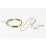 A green hardstone panel bracelet, the green hardstone batons spaced by pierced circular panels