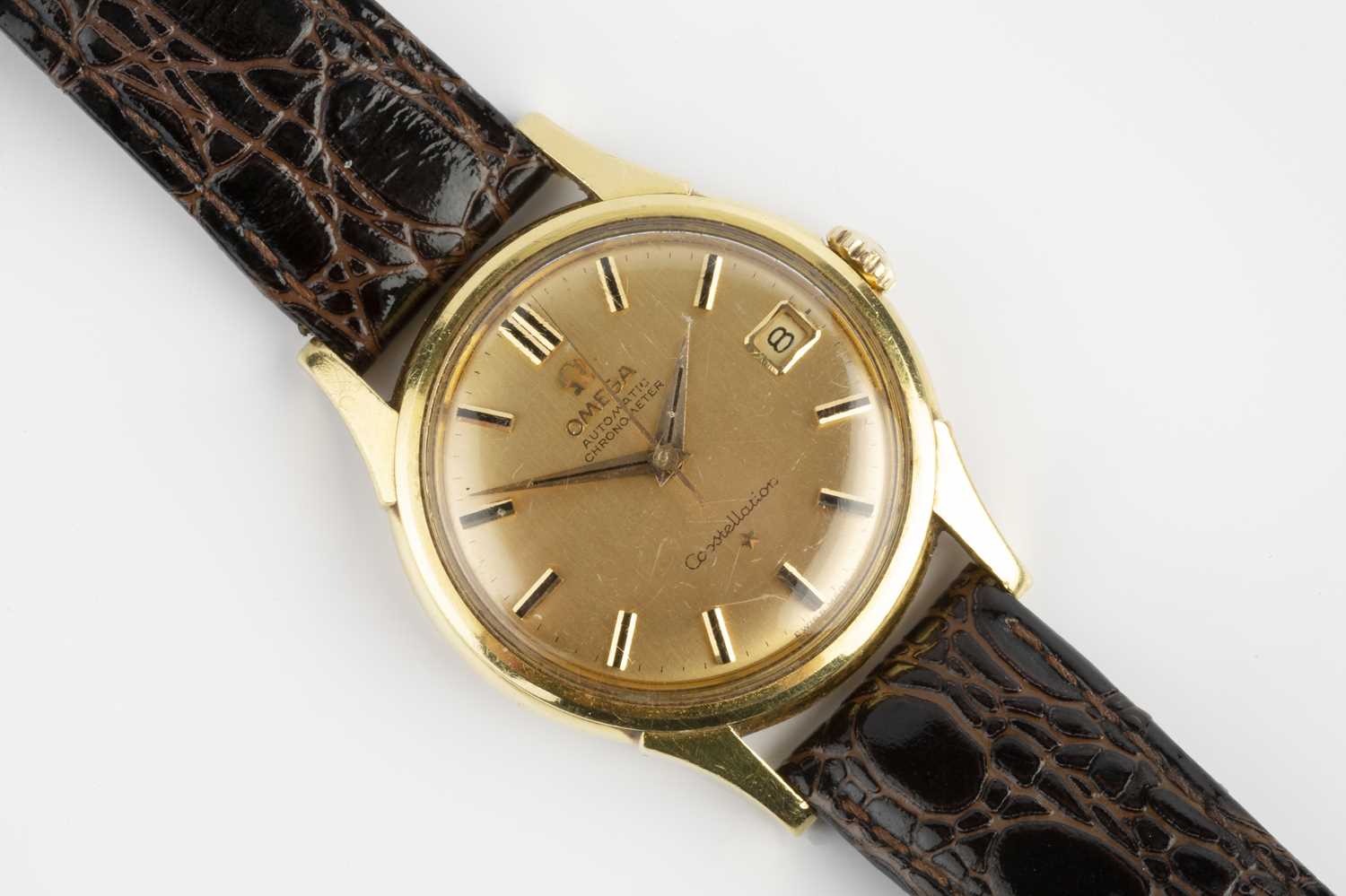 A 'Constellation' automatic wristwatch by Omega, the circular gilt dial with black baton markers,