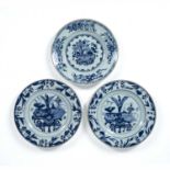 Pair of blue and white plates Chinese, Kangxi each painted with 'antiques' and with foliate borders,
