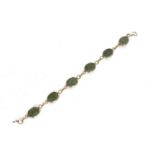 Green hardstone bracelet with yellow precious metal mounts, indistinctly stamped to the clasp,