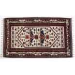 Cream ground rug Afghanistan with central panel of foliate designs within a border of various