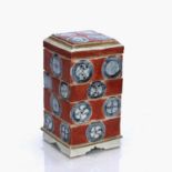 Four tier porcelain stand Japanese, 19th Century painted with Mons type blue roundels on a clay