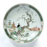 Famille verte charger Chinese, 19th Century depicting a man sitting on a tree branch playing an