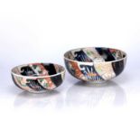 Two en suite Imari bowls Japanese decorated with a six bladed windmill style dark blue ribbons