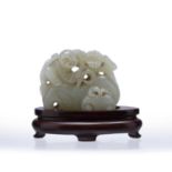 Carved jade figure of a boy Chinese depicted climbing on fruit, with a fitted stand, 5cm