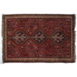 Pale red ground rug Afghanistan with three central medallions and stylised birds and animals