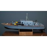 A model torpedo boat with machine gun and two model torpedoes on deck, single screw engine, on