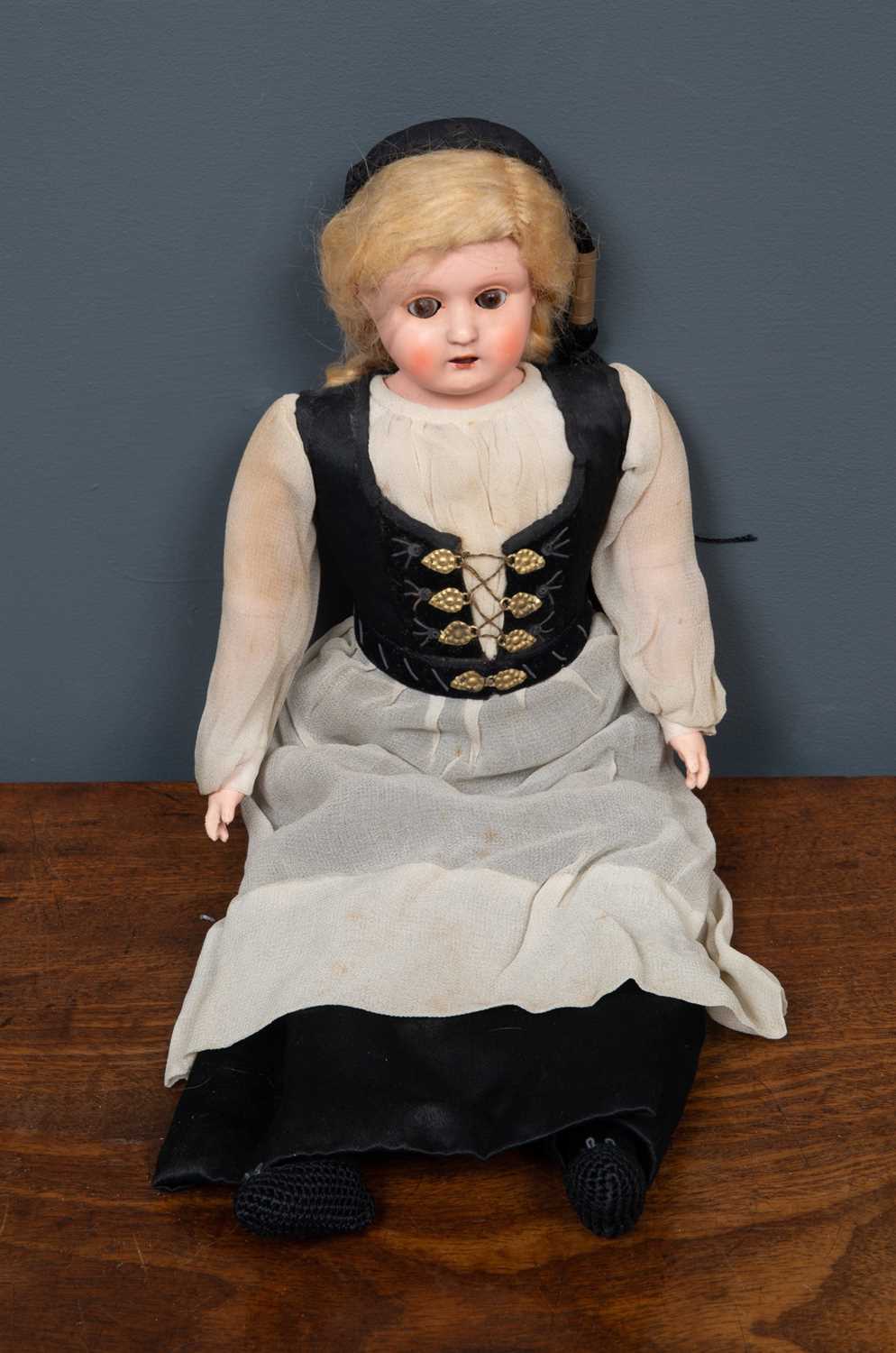 A vintage doll with rolling eyes in black and white traditional dress, plastic head and lower arms