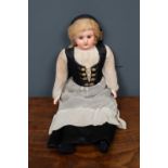 A vintage doll with rolling eyes in black and white traditional dress, plastic head and lower arms