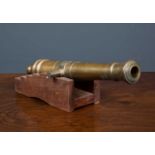 An old brass model or signalling cannon, on a stepped wooden base, 28cm long overallCondition