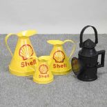 A set of three Shell advertising jugs, together with a vintage style railway lamp