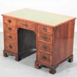 An early 20th century walnut and cross banded pedestal desk,