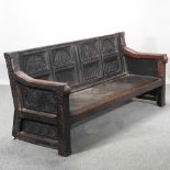 An 18th century and later carved oak settle,