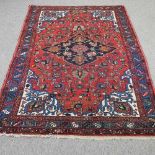 A Persian style woollen rug, with a central medallion,