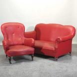 A 1920's red vinyl upholstered sofa, 144cm, together with a matching armchair