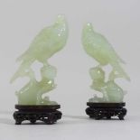 A pair of oriental carved jade coloured stone birds,