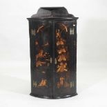 A George III black japanned bow front hanging corner cupboard,