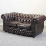 A brown leather upholstered chesterfield sofa,