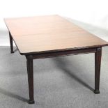 An Edwardian mahogany pull out extending dining table,