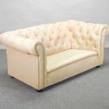 A 1920's cream upholstered chesterfield sofa,