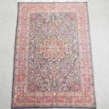 A Persian woollen rug, with all over foliate design,