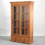 A modern light oak glazed cabinet