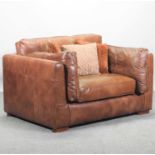 A large brown leather upholstered armchair,