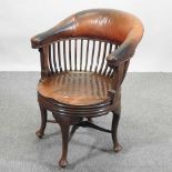 A late Victorian oak and leather upholstered swivel desk chair,