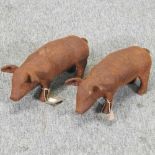 A pair of small rusted iron models of pigs