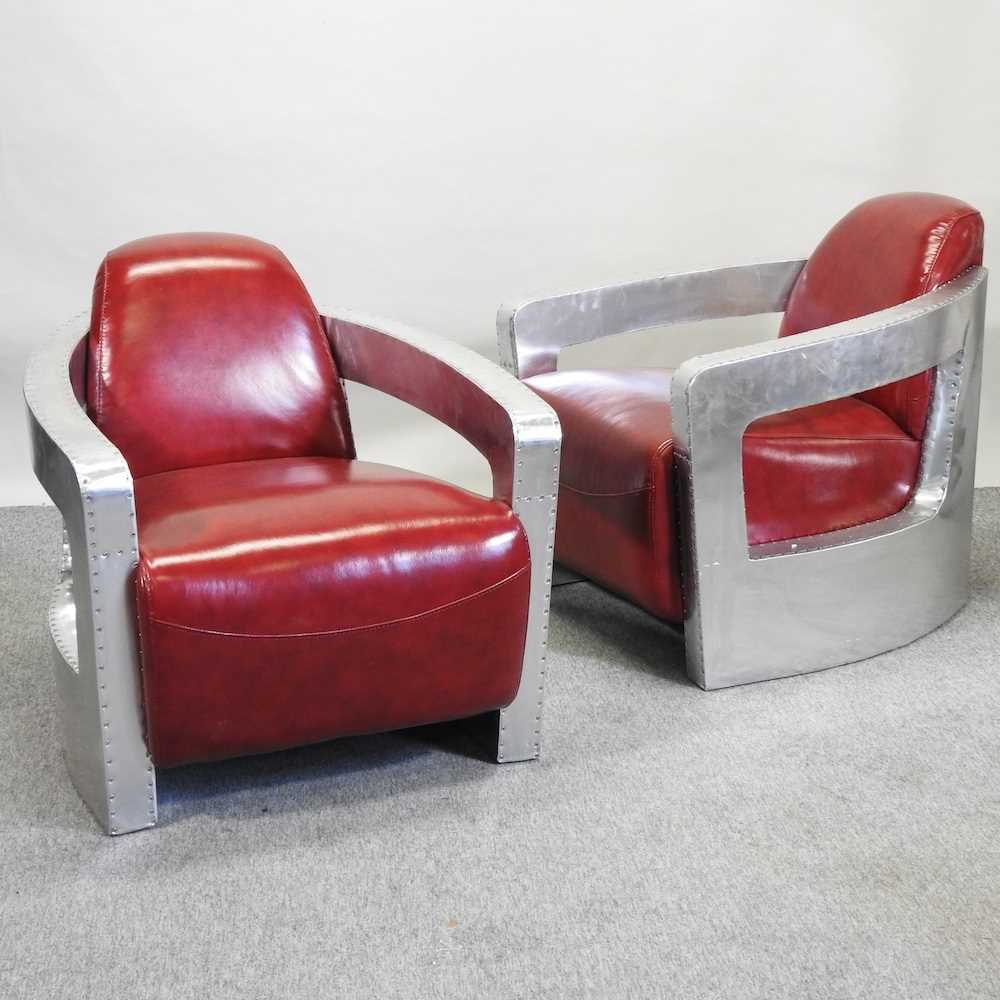 A pair of Art Deco style red upholstered aviator style armchairs,