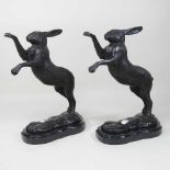 A pair of bronze models of boxing hares,