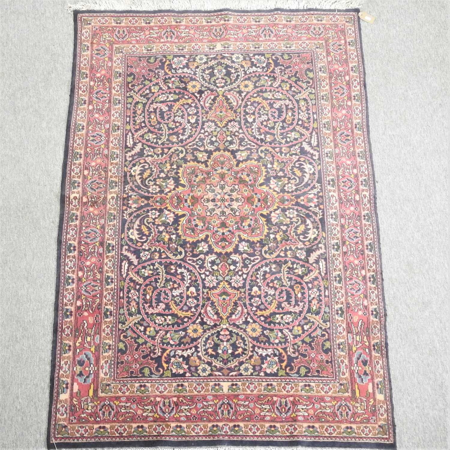 A Persian woollen rug, with all over foliate design,