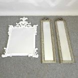 A pai of ornate silver painted bevelled glass wall mirrors