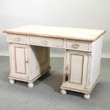 A cream painted pedestal desk