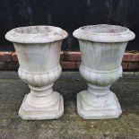 A near pair of reconstituted stone garden urns
