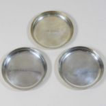 A set of three silver coasters