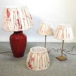 A large red pottery table lamp and shade