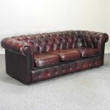 A red upholstered chesterfield sofa