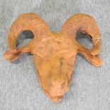 A rusted metal model of a ram's head