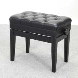 A modern black upholstered piano stool