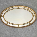 An early 20th century gilt framed oval wall mirror