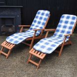 A pair of teak folding garden steamer chairs