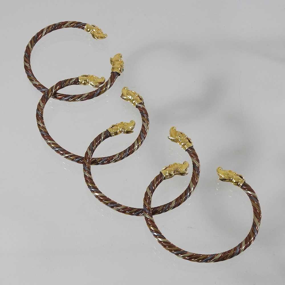A set of four Chinese bangles of twisted design